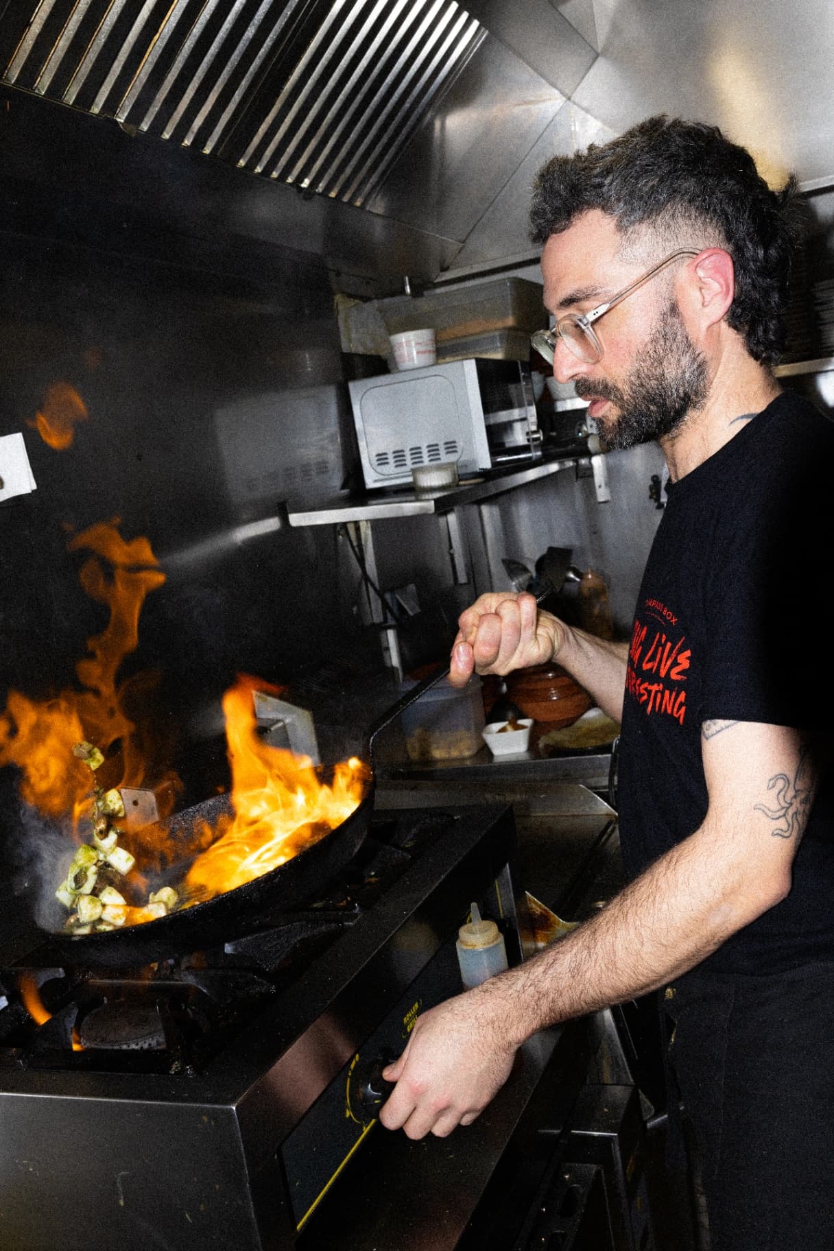 Cuisinier qui fait flamber une poêle
